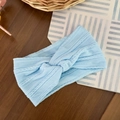 Detailed close-up of light blue ribbed knit baby headband with a twisted knot design - Blue