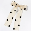 Detailed macro view of polka dot champagne organza bow hair clip with sheer texture - Khaki