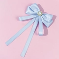 Detail of light blue satin ribbon bow with center faux pearl and gold beads on pink background - Blue
