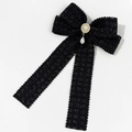 Detalle de pasador de lazo de tweed con perla central y colgante de perla en gota - Negro
