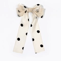 Détail d'une pince à cheveux en satin champagne à pois noirs avec de longs rubans - Kaki