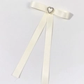Gros plan d'un nœud papillon en satin crème avec strass coeur et longs glands - Beige