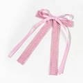 Detail of pink silk ribbon bow with intricate lace streamers and delicate cutout floral patterns - Pink