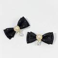 Detailed macro view of black herringbone bow clips with pearls and studs in pair - Black