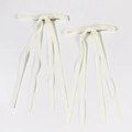 Détail de barrettes nœuds en velours blanc crème avec longs rubans et clips en métal - Beige