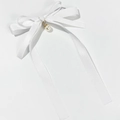 Dettaglio del fiocco in nastro bianco con perla elegante e base in metallo dorato - Bianco