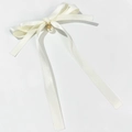 Dettaglio del fermaglio a fiocco in raso bianco con elegante perla sintetica e pendente oro - Beige
