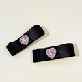 Dettaglio macro di fermagli a fiocco in seta con strass a cuore rosa e perle - Nero