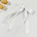 Gros plan d'une élégante pince à nœud en satin blanc avec rubans longs et texture soyeuse - Blanc