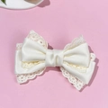 Elegante pinza para el pelo con lazo de encaje y satén marfil sobre fondo rosa suave - Beige