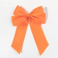 Dettaglio di un fermaglio per capelli con fiocco in nastro grosgrain arancione brillante - Arancione