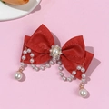 Détail d'un nœud papillon en satin rouge avec glands en perles et centre de fleur en cristal - Rouge