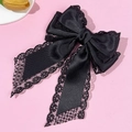 Nahaufnahme der schwarzen Satin-Haarschleife mit zarter Spitze und eleganter Textur - Schwarz