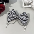 Macro shot of Gothic lace bow with heart gem and silver cross chain detail - Black and White