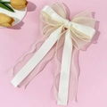 Detail of elegant cream white mesh bow hair clip with satin ribbons on pink background - Beige