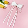 Dettaglio del fermaglio per capelli con fiocco bianco a strati, perle e nastri lunghi - Bianco