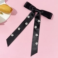 Detail der schwarzen Satin-Schleifen-Haarklammer mit silbernen Glitzersternen auf Rosa - Schwarz