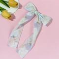 Detail einer hellblauen Haarklammer mit großer Schleife und langen Bändern auf Rosa - Blaue Haarspange