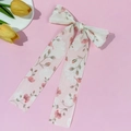 Nahaufnahme der eleganten Blumen-Haarschleife mit zarten rosa Blütenmustern - Rosa Haarklammer