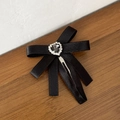 Close-up of black satin bow hair clip with a sparkling heart rhinestone center - Black