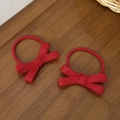 Primer plano de gomas para el pelo con lazo rojo y textura acanalada sobre madera - Rojo