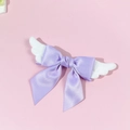 Detail view of a purple satin bow hair clip with white plush angel wings in Lolita style - Purple