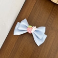 Détail d'un nœud papillon en satin bleu clair avec breloques fraise et lapin mignon - Bleu