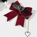 Detail of burgundy gothic bow hair clip with leather strap, silver buckle and heart chain - Burgundy