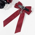 Macro detail of wine red gothic bow hair clip with leather strap and silver heart pendant - Burgundy