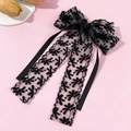 Elegant black lace bow hair clip with long floral embroidery ribbon on soft pink background - Black