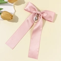 Nahaufnahme einer rosa Satinschleife Haarspange mit Herz und Kreuz Anhänger - Rosa