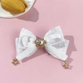 Detalle de pinza de lazo de satén blanco con diamantes de corazón y colgantes de estrella - Blanco