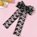 Detalle de pasador para el pelo con lazo de encaje negro, bordado floral y cintas largas fluidas - Negro