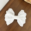 Detailed view of white floral lace bow hair clip with scallop edges on dark wood surface - White Hollow Out Lace Style (1#)