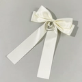 Detail view of cream satin bow hair clip with silver heart cross pendant ornament - Beige