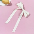 Makroaufnahme einer weißen Satin-Haarschleife mit langen Bändern auf rosa Hintergrund - Beige