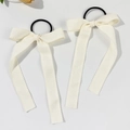 Primer plano de coleteros con lazo de encaje crema con cintas largas suaves - Coletero beige