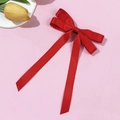 Detail of red satin ballet bow hair clip with long ribbons on pink background - Red
