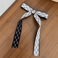 Detalle de un lazo para el pelo blanco y negro con bordes ondulados sobre madera oscura - 1# (Negro y Blanco Borde Ondulado)