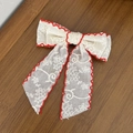 Détail de broderie de fleurs rouges sur une pince à cheveux en dentelle crème - Rouge
