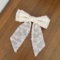 Détail d'une pince à cheveux nœud en dentelle avec broderie florale et bordure rose - Rose