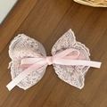 Detail of pink lace bow hair clip featuring delicate floral mesh and smooth satin ribbon - Pink