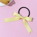 Sweet light yellow satin bow hair tie with black elastic band on soft pink background - Yellow