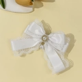 Detailed close-up of white lace bow hair clip with elegant pearl pendant and gold inlay - White