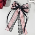 Detail der Haarklammer mit rosa Satin, schwarzer Spitze, Herzjuwel und bedrucktem Band - Rosa