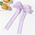 Close-up of lilac mesh ribbon hair clip with wavy stitching and elegant long streamers - Purple
