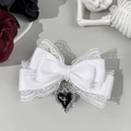 Close-up of a white lace bow hair clip featuring a black heart and silver cross pendant - White