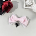 Detail of pink satin bow hair clip with white lace trim and black heart cross pendant - Pink