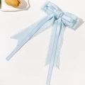 Détail d'une pince à cheveux nœud en satin bleu clair avec bordure en dentelle - Bleu