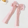 Pink ribbon bow hair clip with floral embroidery and long tassels on white background - Pink